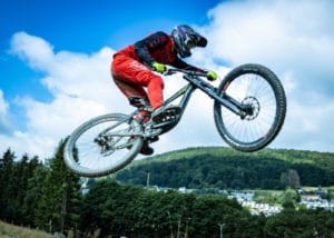 athlete doing a high jump on a downhill mountain bike