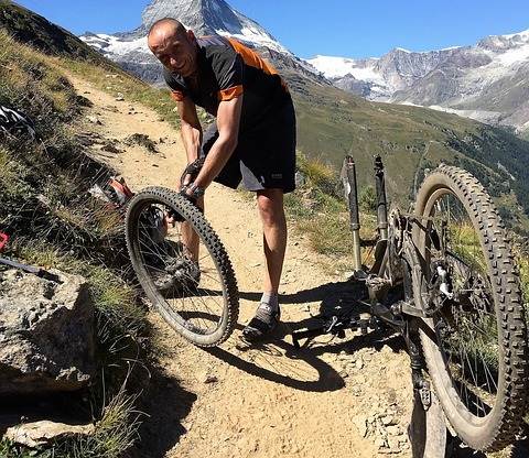 A man putting a new tire on his mountain bike