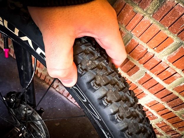 Hand pinching a bike tire