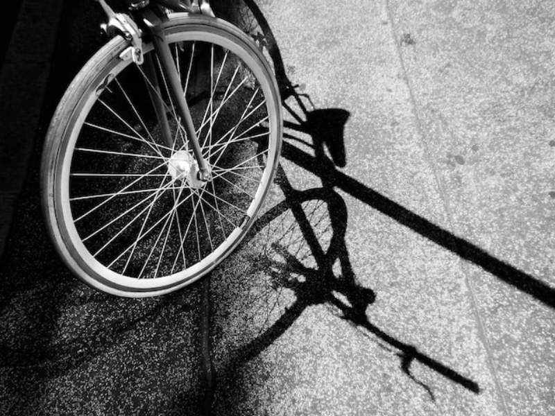 A black and white image of a bike tire and its shadow